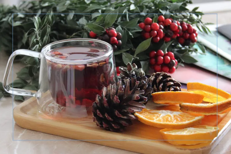 tray of tea and orange slices decorated with pine cones