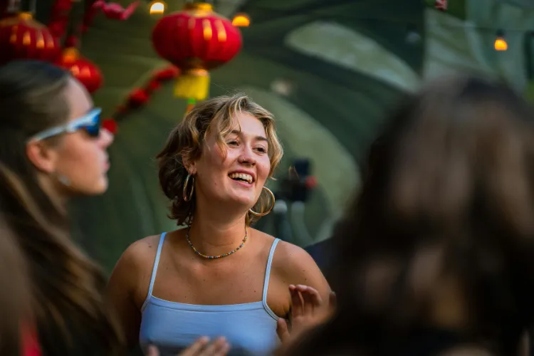 Young woman smiling confidently at a social gathering, illustrating how clear aligners support confidence and a natural smile during social events and special occasions.