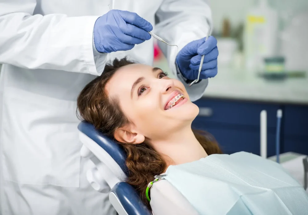 cropped-view-of-dentist-in-latex-gloves-examining-cheerful-woman-in-braces